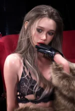Close-up portrait of Callie with smoky eye makeup, ash-blonde hair, a black glove, and soft fur at her shoulder.