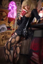 Seated beside the bar, Giselle wears a black corset and patterned tights while holding a red drink at her side.