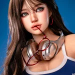 Face close-up of Hanae, a 161cm realistic companion doll, with silver headphones around her neck and red glasses held lightly between her lips.