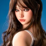 Close portrait of Hanae, a 161cm silicone companion doll, looking back over one shoulder with red glasses resting on top of her dark hair.
