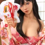 Close-up portrait of Kagura, an Asian silicone doll holding a fox mask.