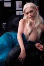 Lottie leans gently toward the armrest, her right hand open beside her while the blue pendant rests over the teal corset and pointed ears remain visible.