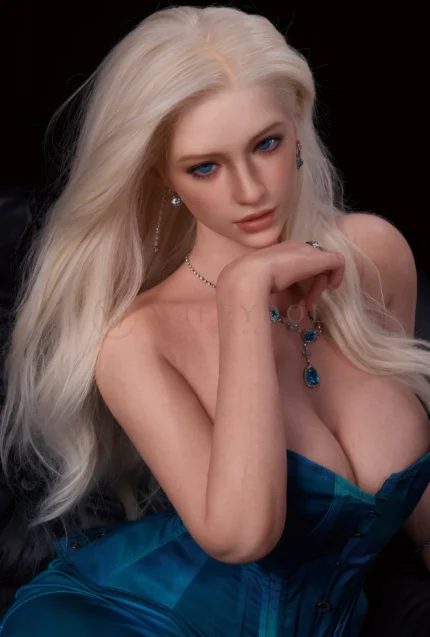 Lottie rests the back of her hand beneath her chin and looks slightly downward, the blue gemstone necklace sitting just above the teal corset neckline.