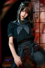Mika, a 161cm realistic companion doll, seated on a dark wooden bench in a navy sailor crop top, pleated skirt, and gray stockings.