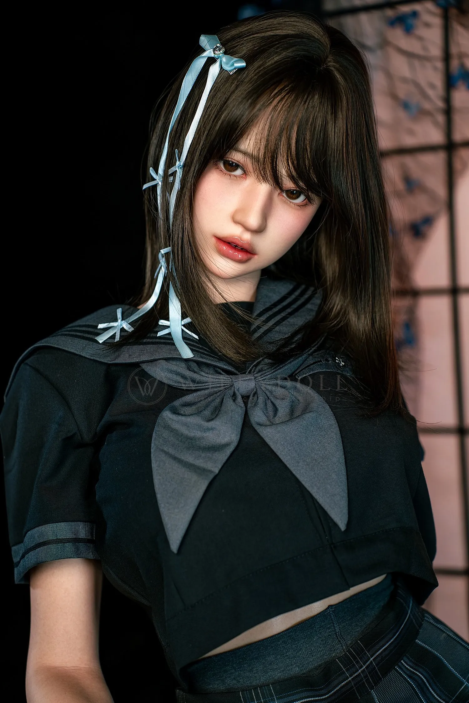Close-up of Mika, a 161cm silicone companion doll, with straight dark hair, blue ribbon accents, and a navy bow at the neckline.