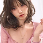 Close portrait of Miku 153cm cute Asian sex doll with one hand resting over her chest.