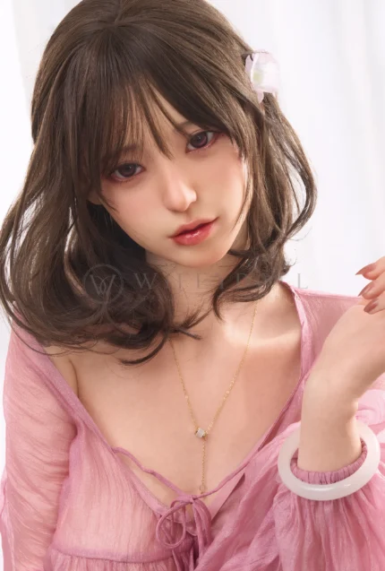 Close portrait of Miku 153cm cute Asian sex doll with one hand resting over her chest.