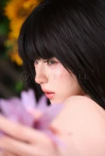 Close-up portrait of Mina, a realistic silicone doll with black bob hair.