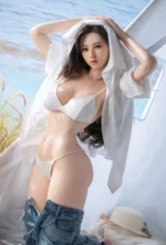 Shizuka life-size silicone doll standing in a beach tent with both hands near her hair.