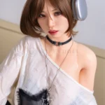 Close portrait of Suki in silver headphones and a black choker, with her white sweater slipped low on one shoulder.