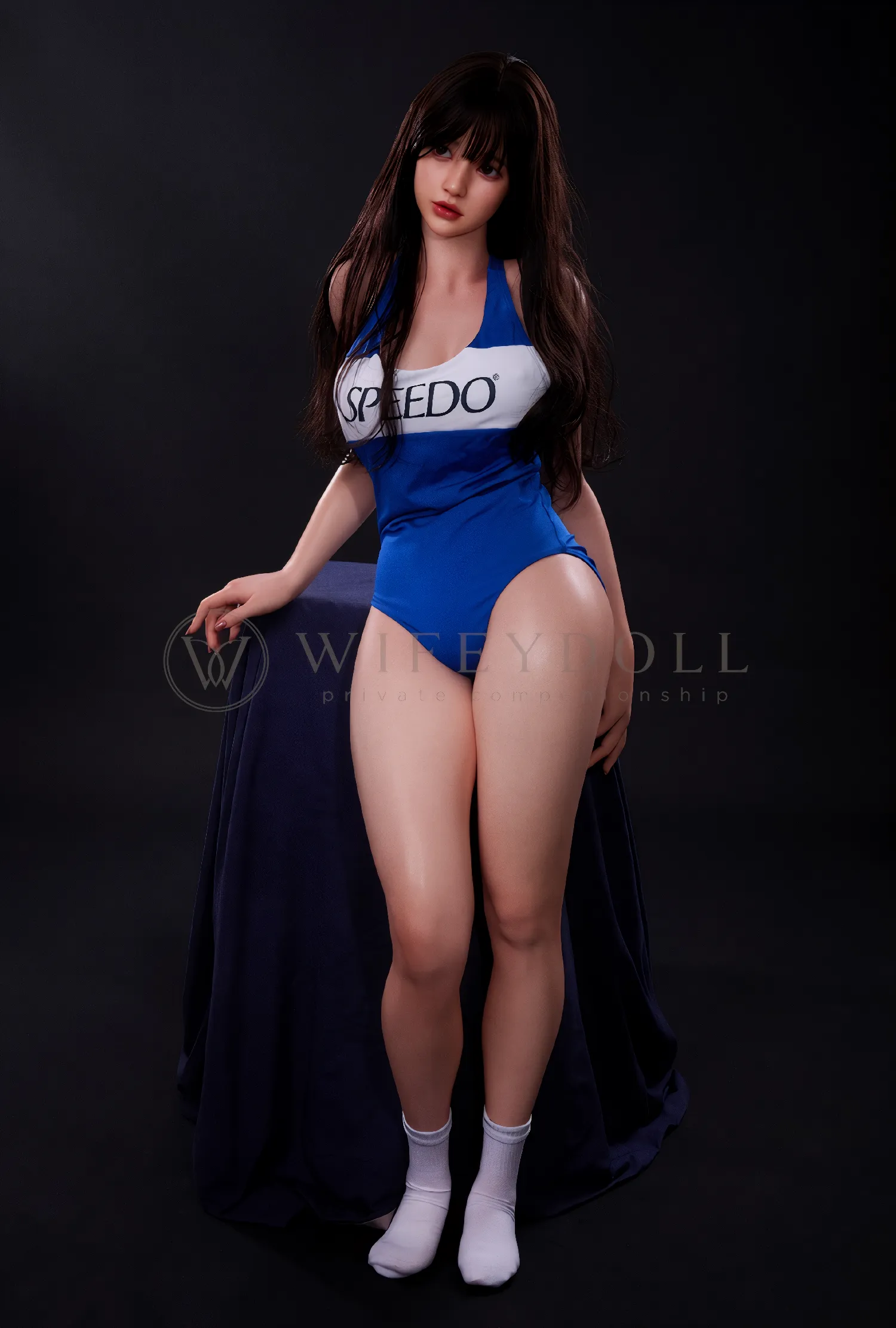 Evie, a 161cm silicone sex doll, standing in a blue-and-white one-piece swimsuit.