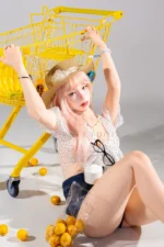 Mio, a 166cm life-size silicone doll, sits on the floor with the yellow cart raised behind her.