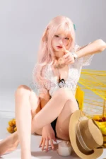 Mio, a 166cm realistic silicone doll, sits on the floor beside her straw hat and oranges.
