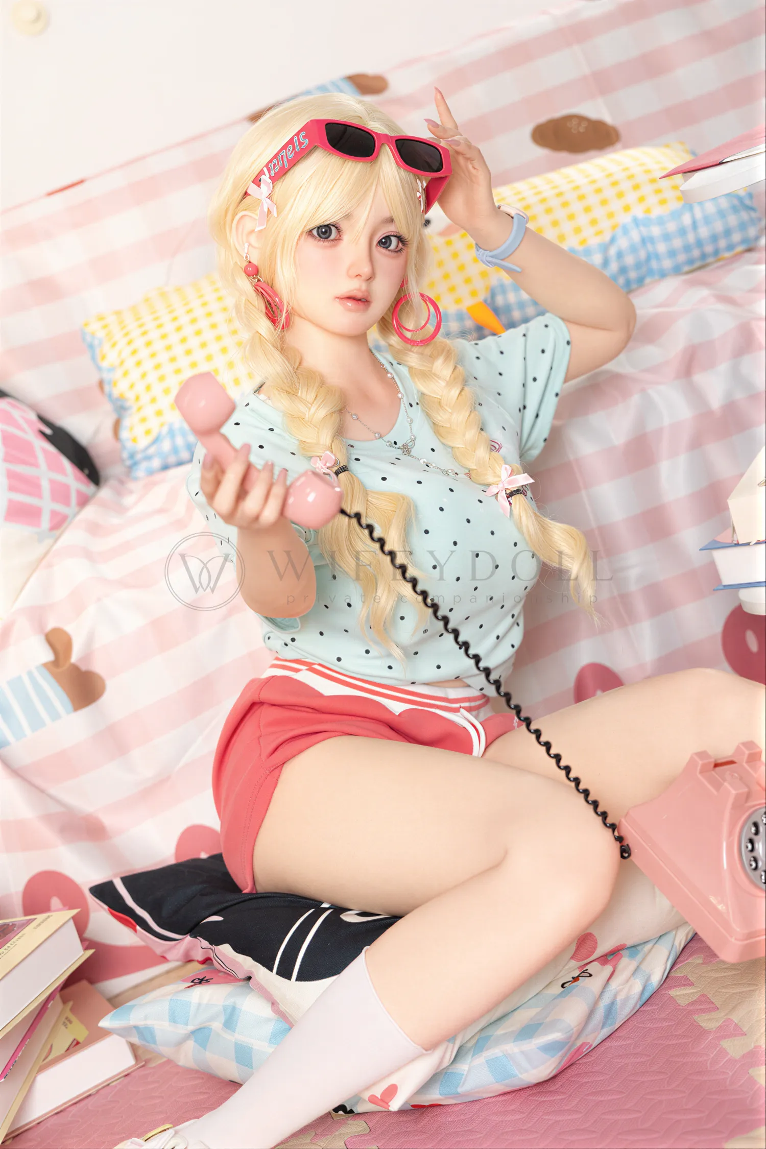 Xia Ying silicone doll reclining on the bed while holding a pink phone handset.