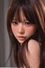 Yuna 153cm silicone doll sits on a bed in magenta lace lingerie and a white top.