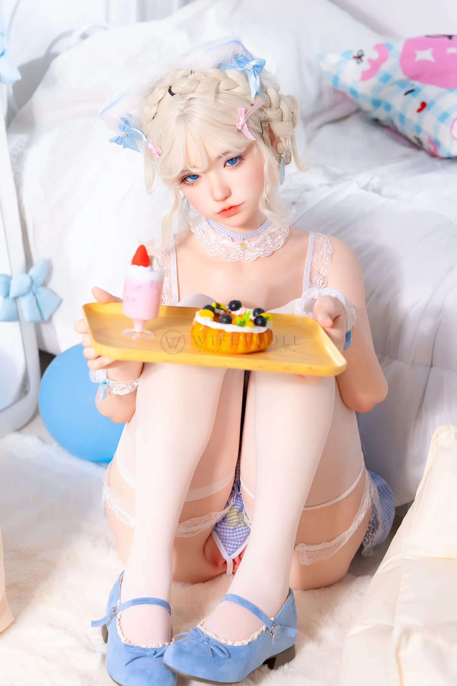 Zia, a 154cm companion doll, sits with her knees drawn together, balancing the yellow dessert tray across them with the blue balloon beside her.