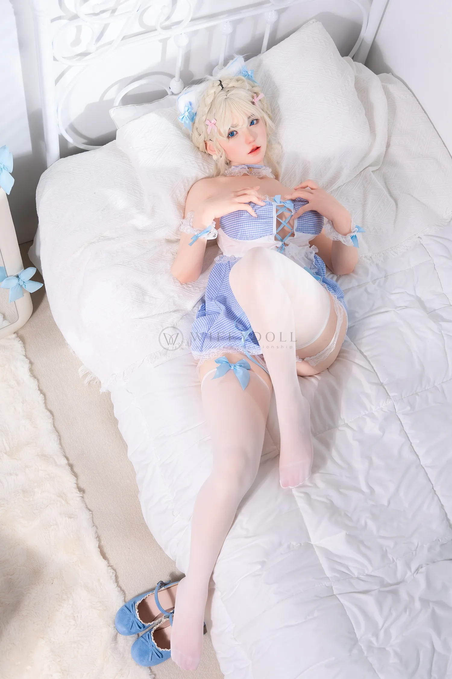 Zia, a 154cm realistic companion doll, lies back across the white bedding, one leg extended and the other bent beneath the blue gingham skirt.