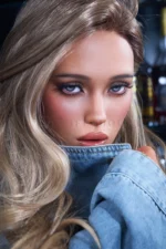One hand lifts into Vera's hair while the denim collar frames her face.