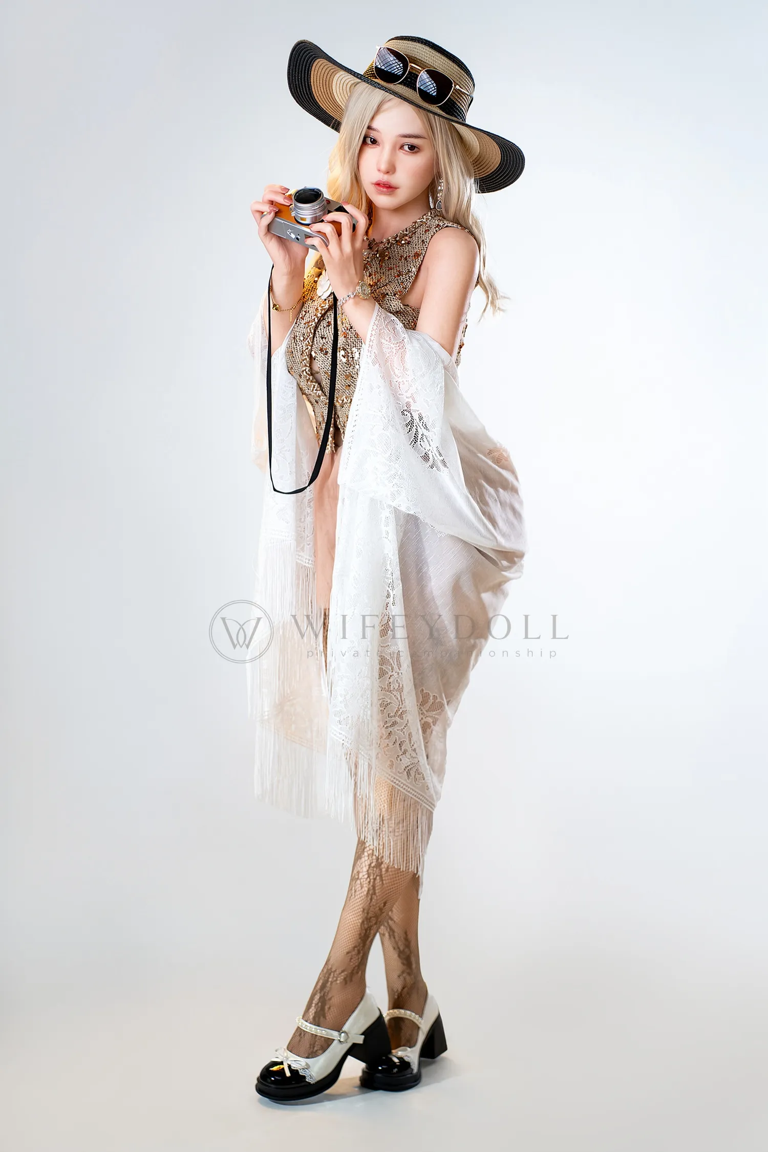 Vivienne silicone sex doll in a fringed lace shawl and straw hat, holding a camera.